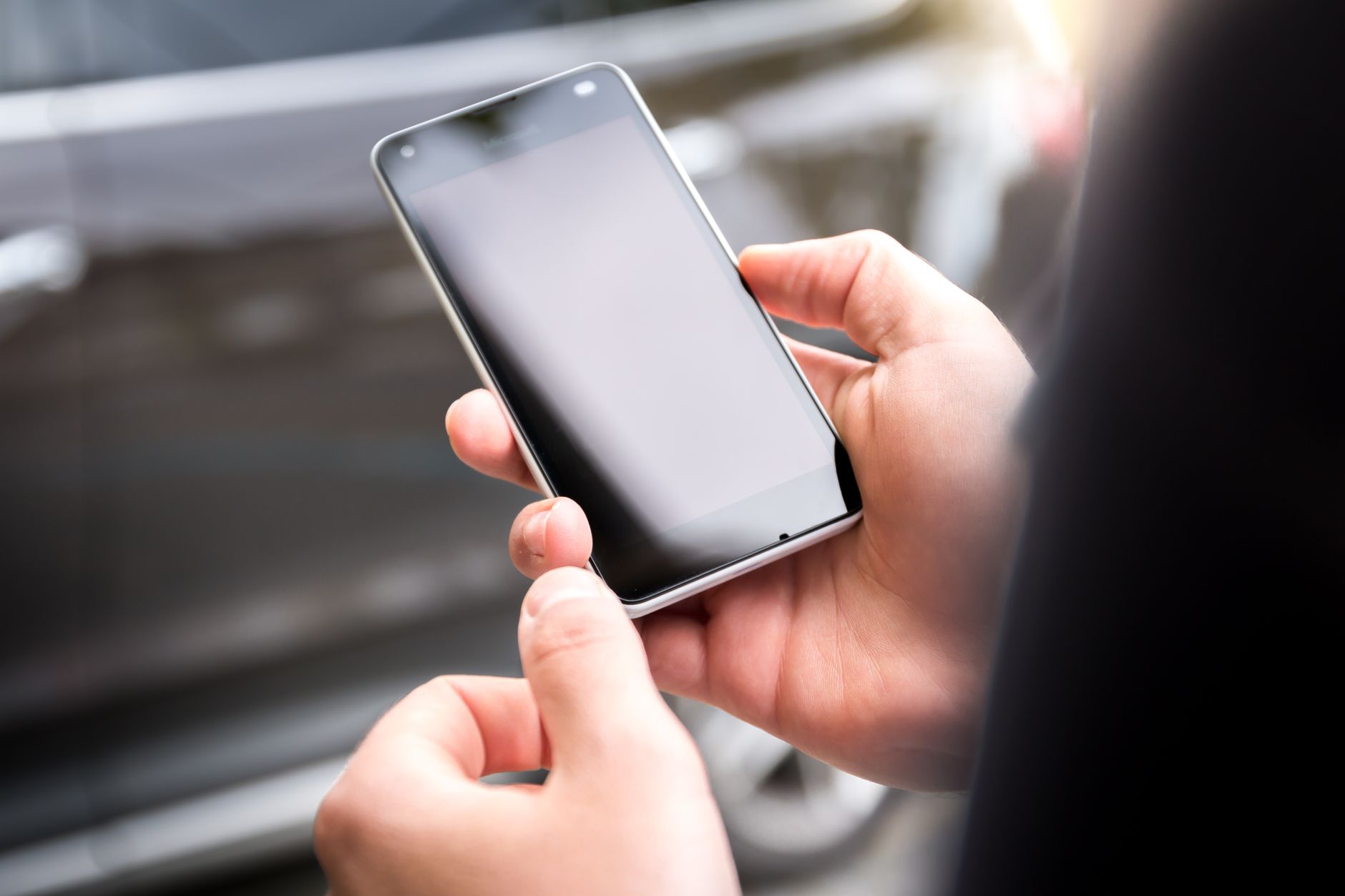 Close-up of someone using a smartphone in the street
